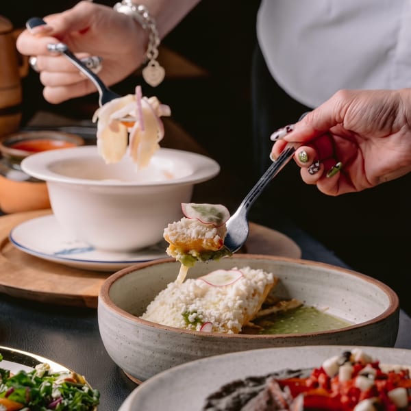 Hands serving various dishes, including a salad, a ceviche, and a main course with cheese.