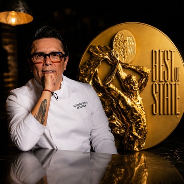 Chef Alfonso Brito Monarca in a white chef's coat next to a large gold "Best of State" medal.