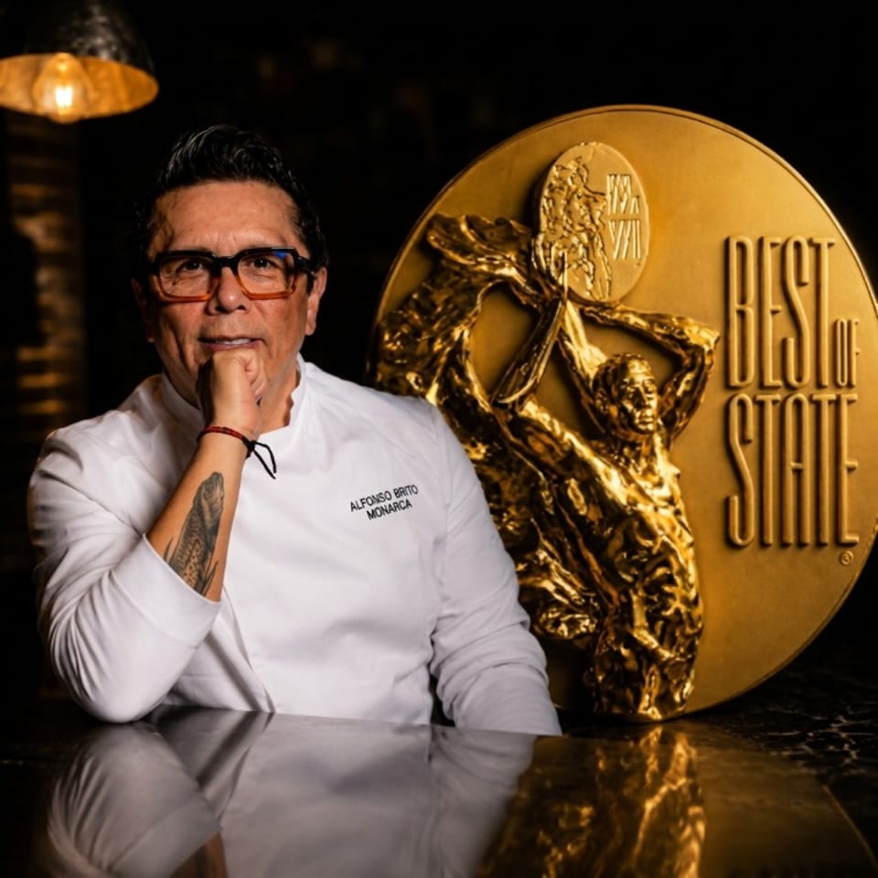 Chef Alfonso Brito Monarca in a white chef's coat next to a large gold "Best of State" medal.